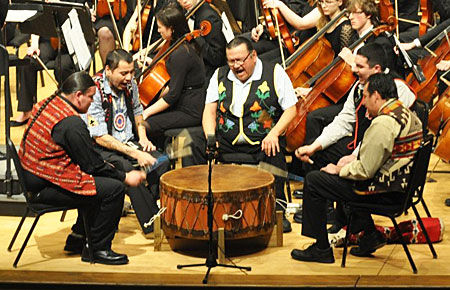 A photo of The Menominee Nation Smokeytown drum group performing on the Lawrence Memorial Chapel stage