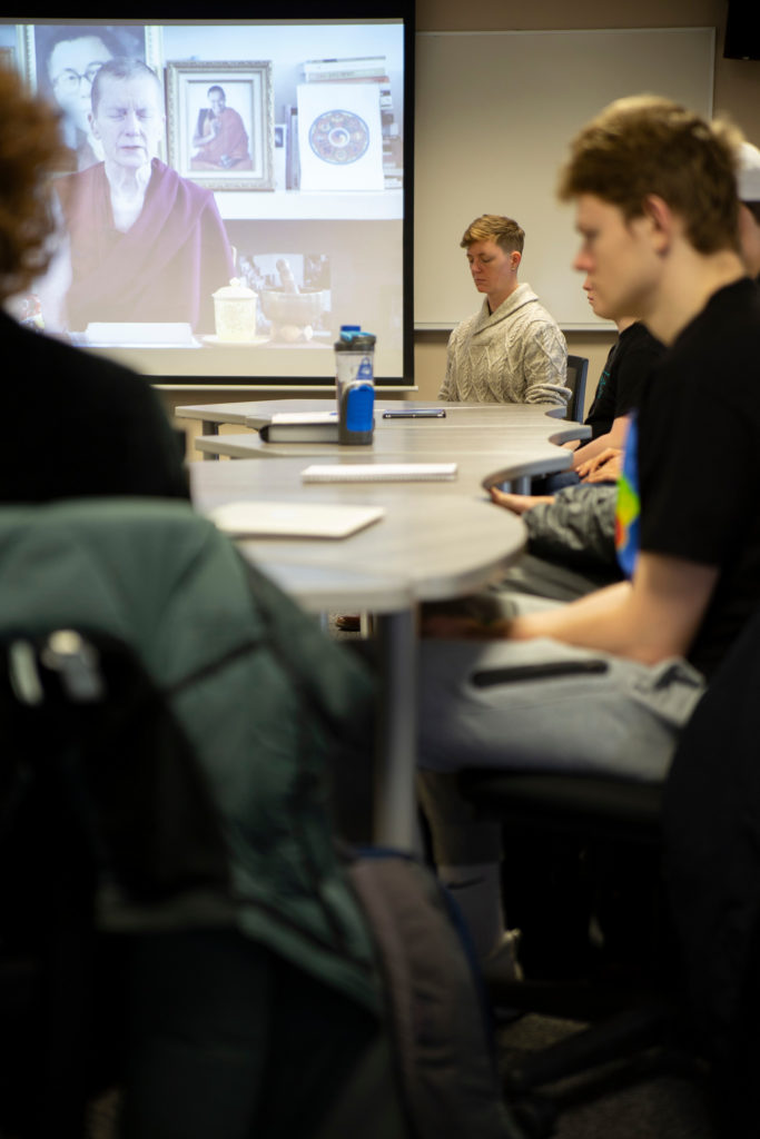 Constance Kassor and students meditating at a table.