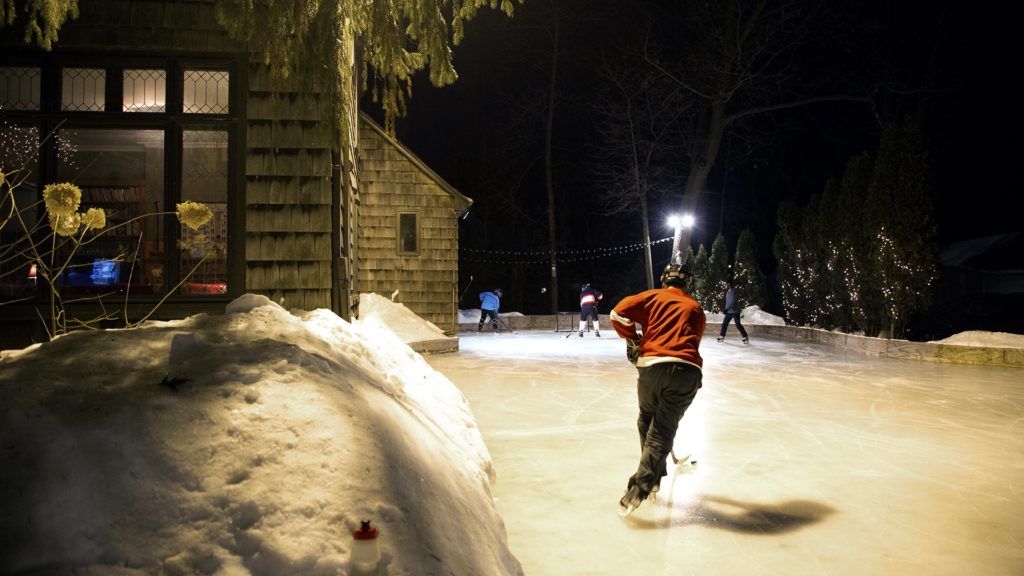 A player brings the puck up the ice during a Tuesday night game at the McKee outdoor rink.